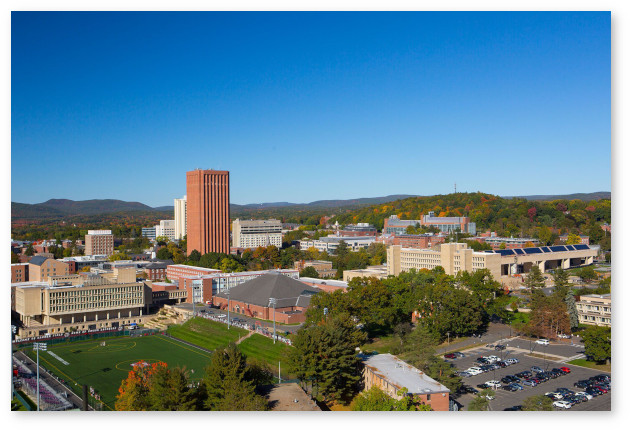 Aerial view of campus looking north from the southwest corner of campus. Many campus bulding are visible, as are the Sunderland hills in the background.