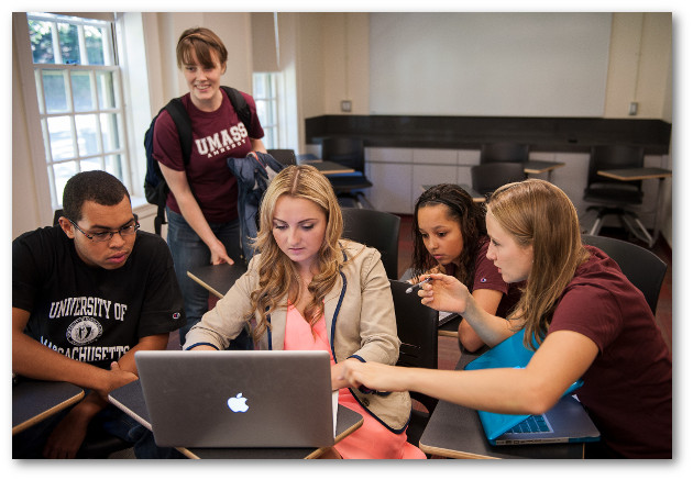 Students gathered around laptop computer