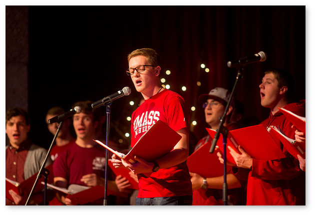 Students holding songbooks and wearing matching red shirts sing during the Winter Welcome.